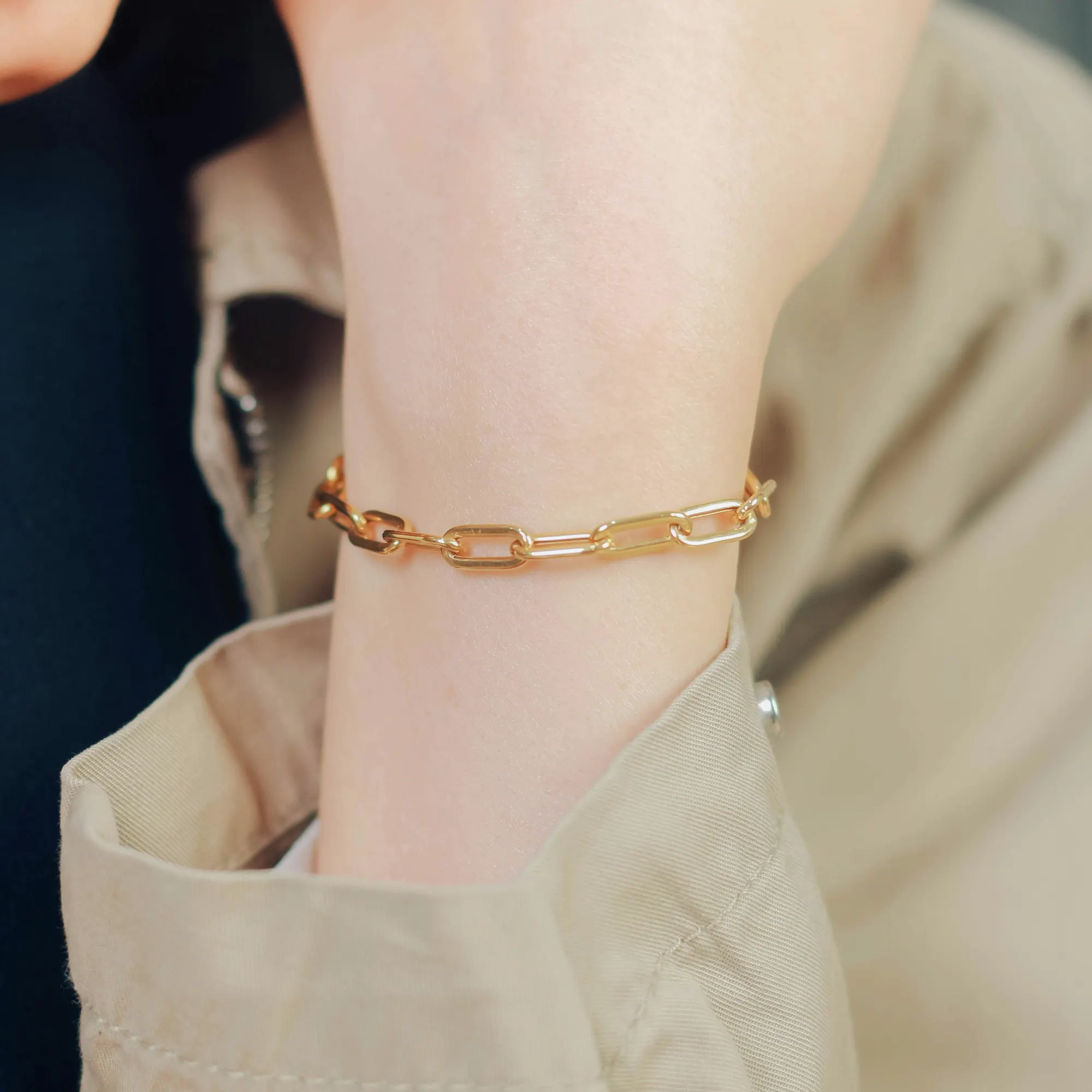 Makroaufnahme eines feinen goldenen Permanent-Armbands an einem Handgelenk
